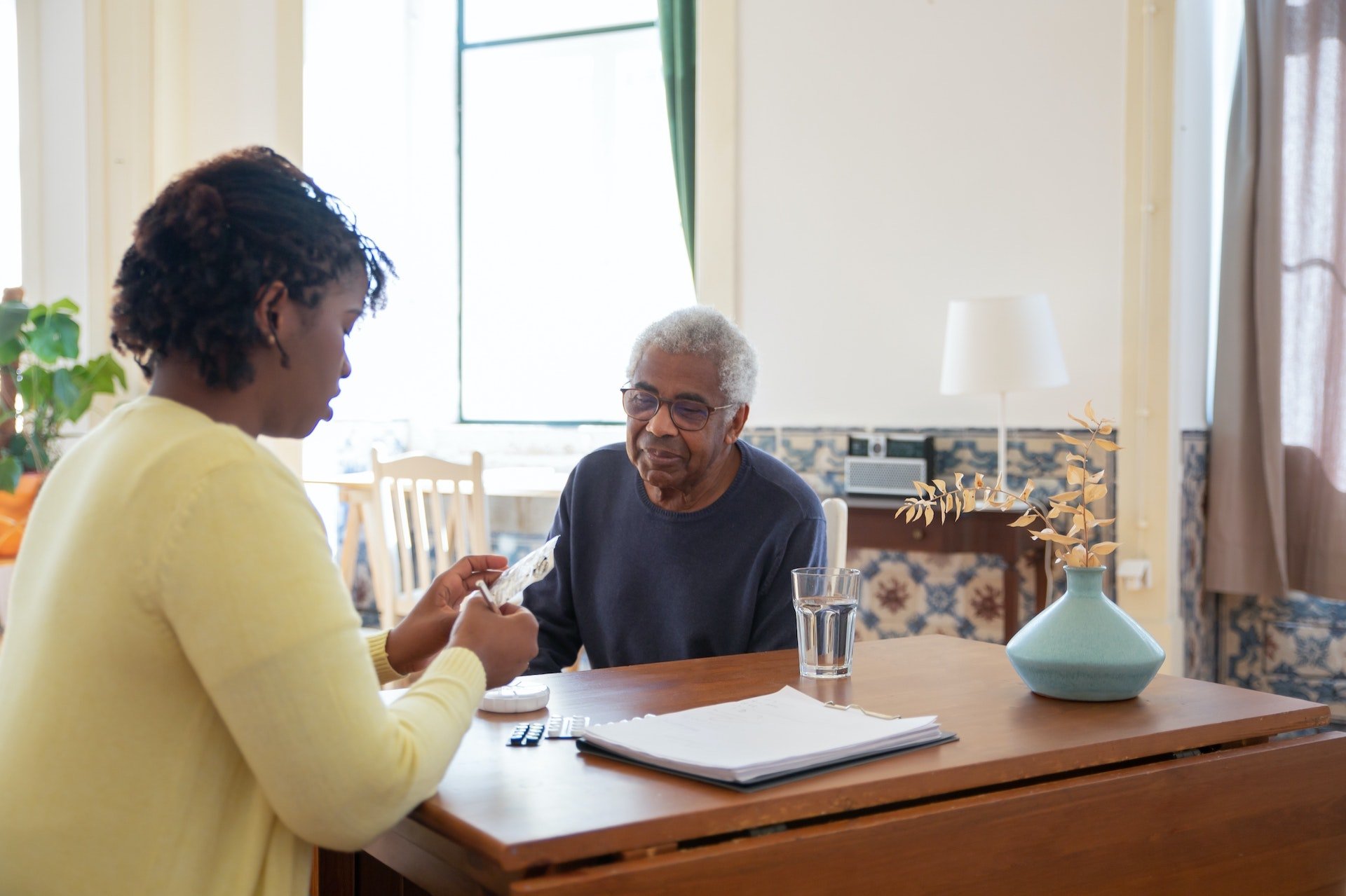 Black-caregiver-helping-elderly-father-with-medication